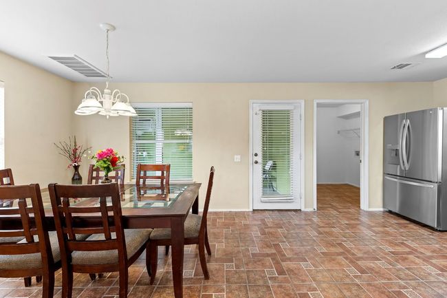Dining area featuring a chandelier and stone finish floors | Image 11