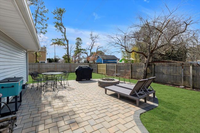 View of patio with outdoor dining area, a fire pit, area for grilling, and a fenced backyard | Image 16