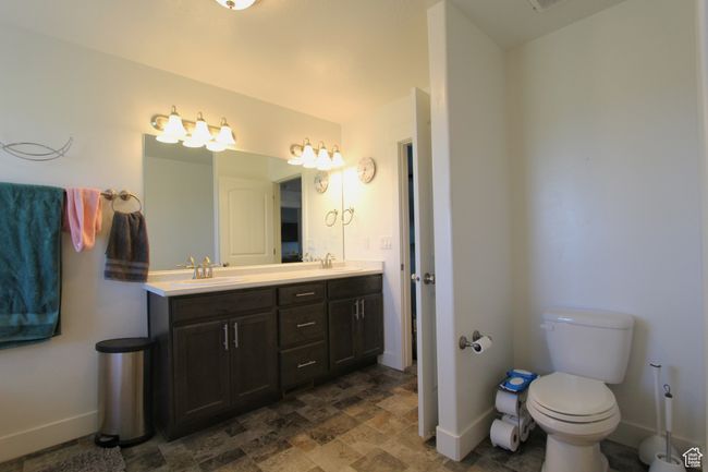 Bathroom with double vanity and stone finish floors | Image 19