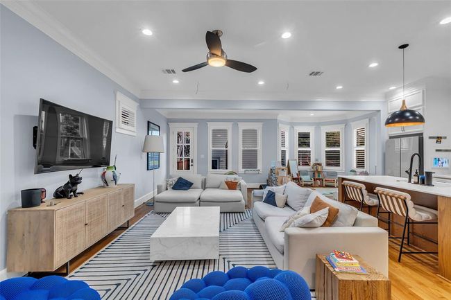 This impressive family room is the hearth of the home. The adjacent kitchen boasts a breakfast bar with pendant lighting, while large windows provide ample natural sunlight. Perfect for entertaining and family living. | Image 14