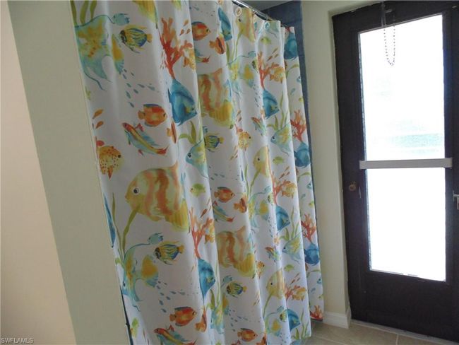 Bathroom with tile patterned floors, curtained shower, and baseboards | Image 22