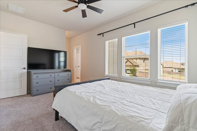 Bedroom featuring visible vents, ceiling fan, and carpet | Image 36