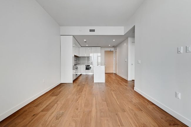 Unfurnished living room featuring light wood finished floors, baseboards, visible vents, and recessed lighting | Image 7