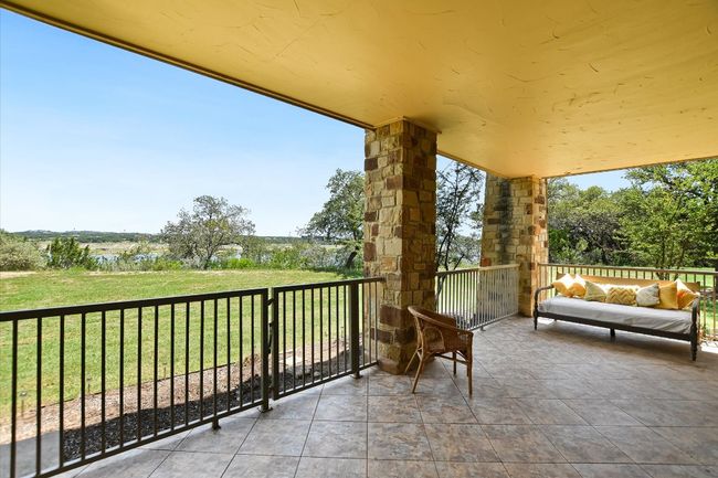 Balcony featuring an outdoor hangout area overlooking the back yard and Lake Travis. Small gate for yard access. | Image 17