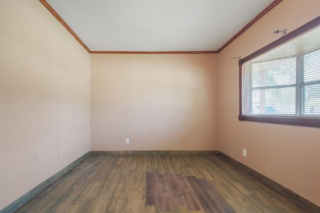 Spare room featuring wood finished floors, baseboards, and ornamental molding | Image 8