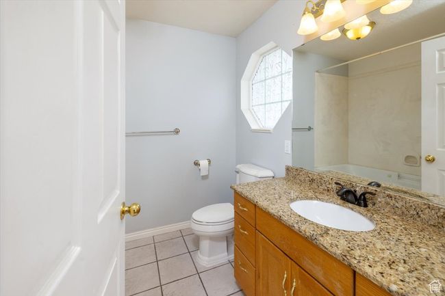 Bathroom off Primary bedroom with tile patterned floors, vanity, and toilet | Image 21