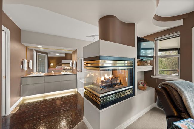 Kitchen with modern cabinets, baseboards, a multi sided fireplace, and a sink | Image 27