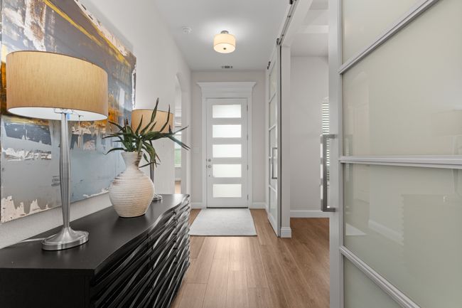 A view of the entryway. Designated study with custom sliding doors on the right, a peek into one of the 2 additional bedrooms with full bath. | Image 5