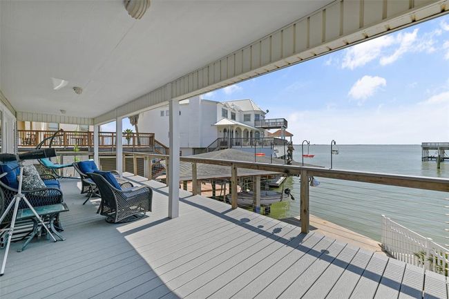 Spacious waterfront deck with seating area, offering stunning views of the water, perfect for relaxation and entertaining. | Image 10