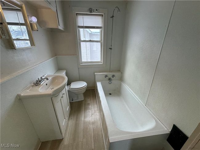 Bathroom with wood-type flooring, a tub, vanity, toilet, and plenty of natural light | Image 4