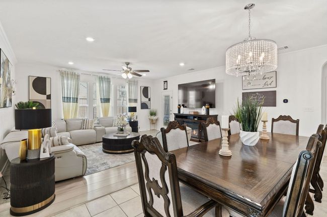 Dining room with crown molding, a chandelier, ceiling fan, arched walkways, and recessed lighting | Image 13