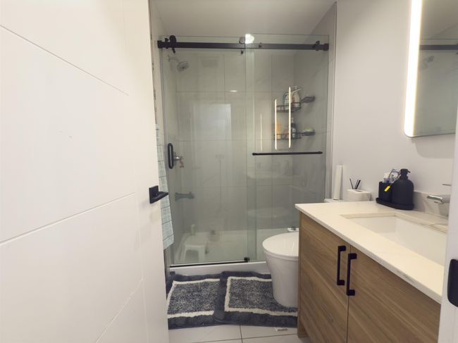 Full bathroom with tile patterned flooring, a shower stall, vanity, and toilet | Image 14
