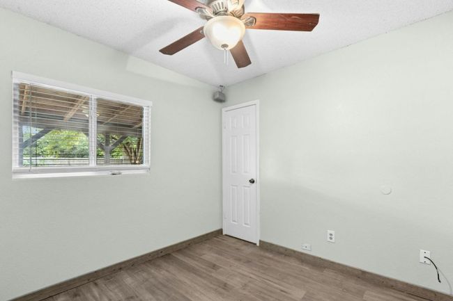 Unfurnished room featuring wood finished floors, a textured ceiling, and a ceiling fan | Image 23