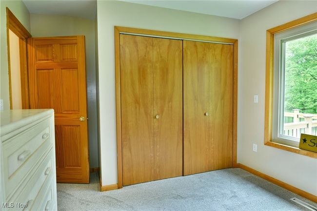 Unfurnished bedroom with a closet, multiple windows, and carpet flooring | Image 22