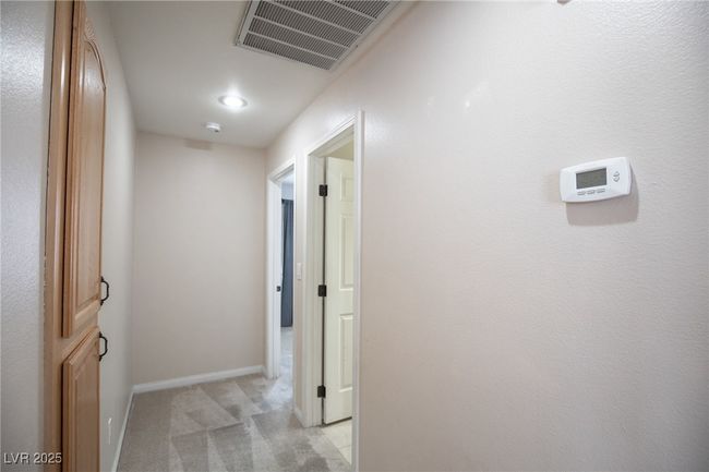 Corridor featuring visible vents, light carpet, and baseboards | Image 23