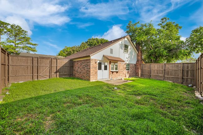 Rear view of house with brick siding and a fenced backyard | Image 22