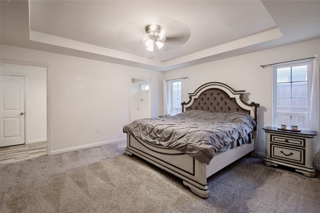 Bedroom with a raised ceiling, carpet, and multiple windows | Image 17