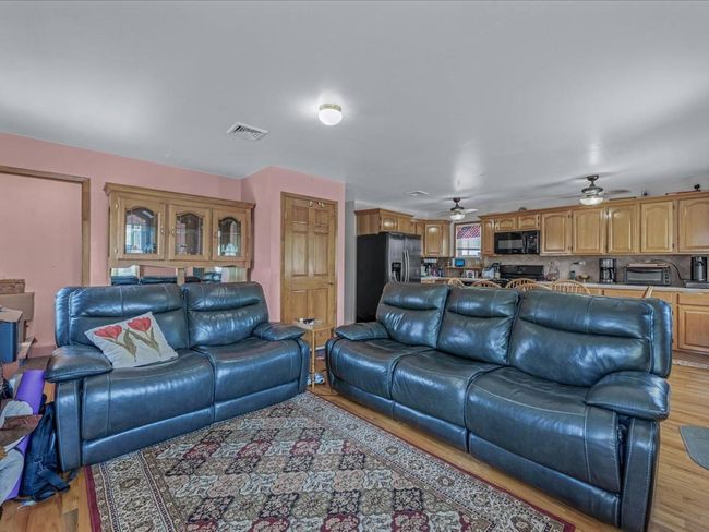 Living room with light wood-style floors and ceiling fan | Image 17