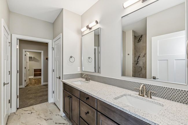 Bathroom with backsplash, double sink vanity, and tile floors | Image 10