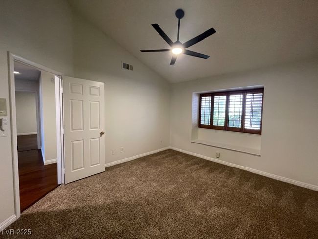 Spare room with dark colored carpet, a ceiling fan, and high vaulted ceiling | Image 20