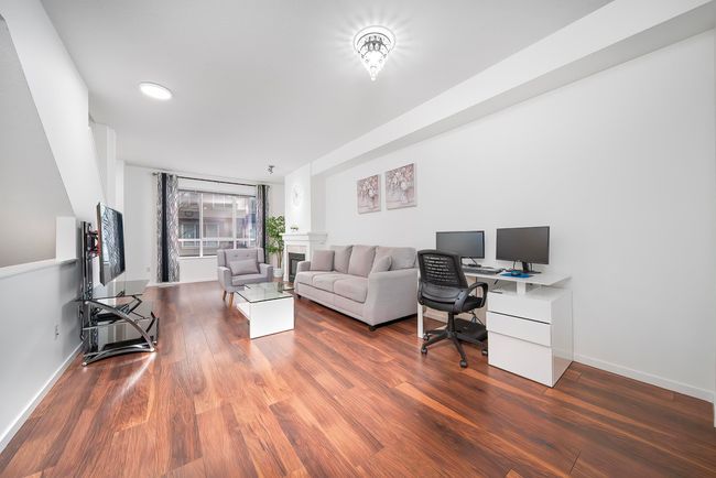 Office space with baseboards, wood finished floors, and a fireplace | Image 7