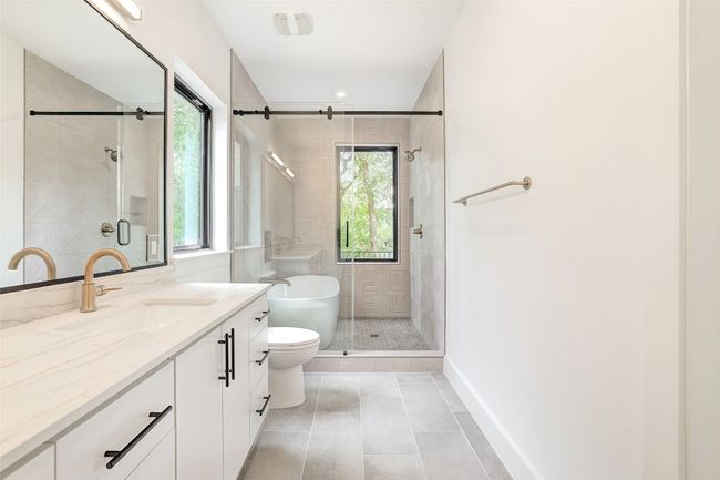 Bathroom with vanity, a shower stall, and tile patterned floors | Image 22