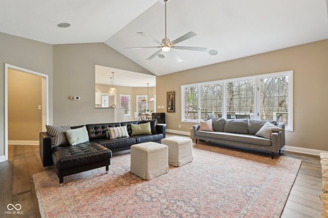 living room featuring high vaulted ceiling, baseboards, ceiling fan, and wood finished floors | Image 22