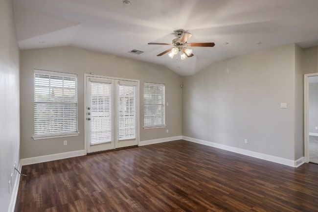 Large family room featuring ceiling fan, vaulted ceiling, dark laminate wood-floors | Image 4