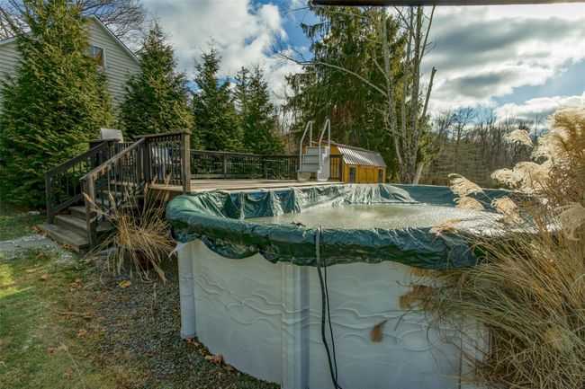 View of swimming pool with a storage shed and a deck | Image 31
