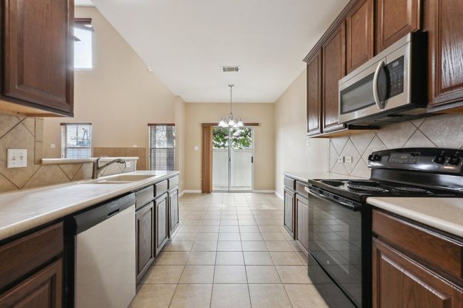 Kitchen with visible vents, stainless steel appliances, backsplash, and a sink | Image 14
