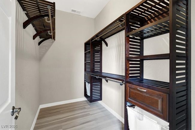 Spacious closet / Primary bedroom featuring visible vents and wood finished floors | Image 22
