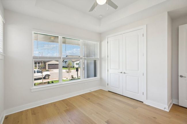 Unfurnished bedroom with a tray ceiling, baseboards, a closet, and light wood-style floors | Image 18