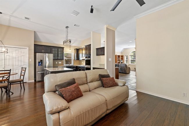 Living area featuring vaulted ceiling, dark wood-style flooring, baseboards, and ceiling fan | Image 10
