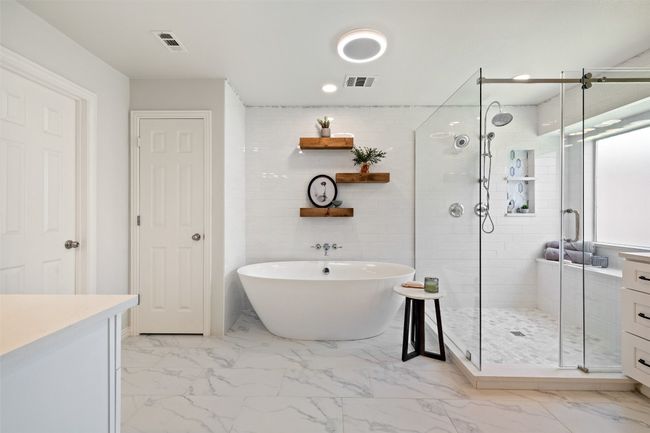 Full bath featuring a stall shower, a freestanding tub, two vanities, and recessed lighting | Image 23