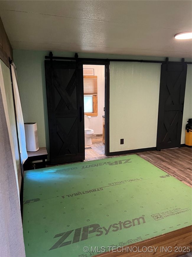 Unfurnished room with a barn door and wood finished floors | Image 14