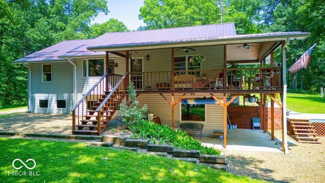 view of front of property featuring ceiling fan, a patio, stairway, and a metal roof | Image 13
