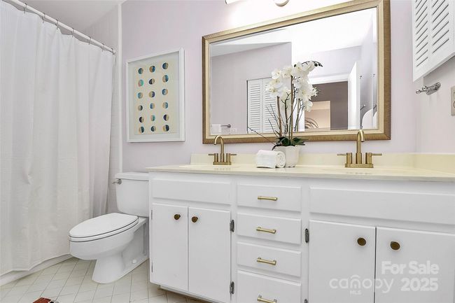 Primary bath with linen closet for storage and dual vanity offers a clean and functional space. | Image 14