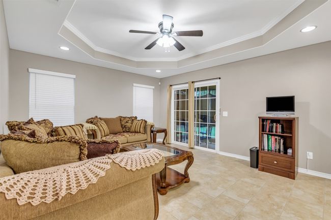 Living room featuring a tray ceiling, ceiling fan, crown molding, and recessed lighting | Image 5