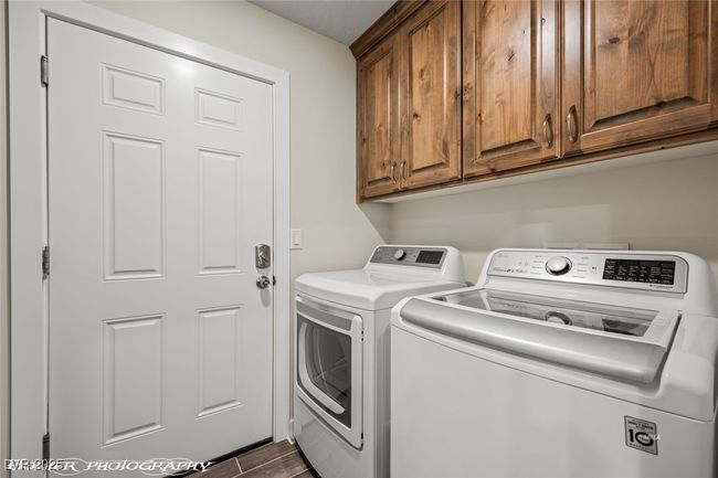 Laundry area with cabinet space, washing machine and dryer, and dark wood-type flooring | Image 34