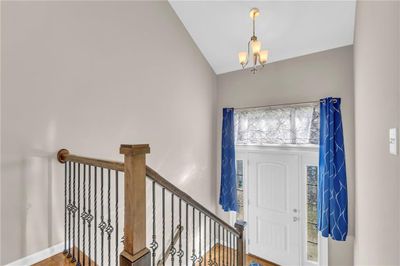 Entrance foyer featuring hardwood / wood-style floors, lofted ceiling, and a notable chandelier | Image 3