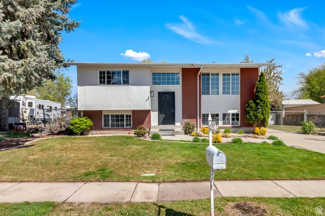 Split foyer home featuring fence, a front lawn, and brick siding | Image 4
