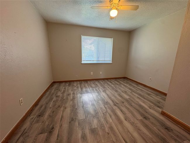 Spare room with wood finished floors, a textured ceiling, and ceiling fan | Image 13