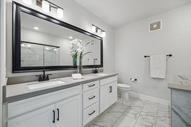 Primary bathroom with a dual-sink vanity, soaking tub, oversized shower, and contemporary fixtures. | Image 10
