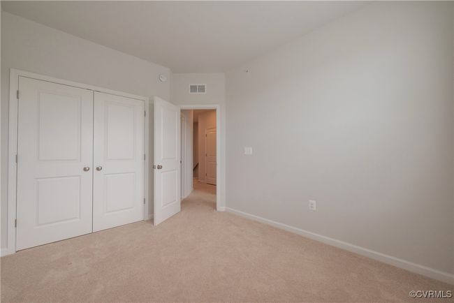 Unfurnished bedroom with a closet, visible vents, baseboards, and light carpet | Image 41