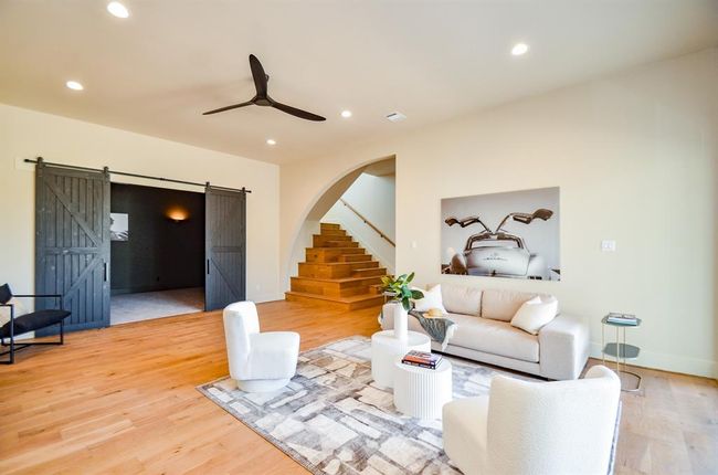 Another living area with barn doors leading to gameroom. Stairs lead to a landing and 2 bedrooms and 2 bathrooms. | Image 46