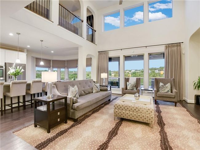Living area with wood finished floors, a towering ceiling, recessed lighting, and arched walkways | Image 10