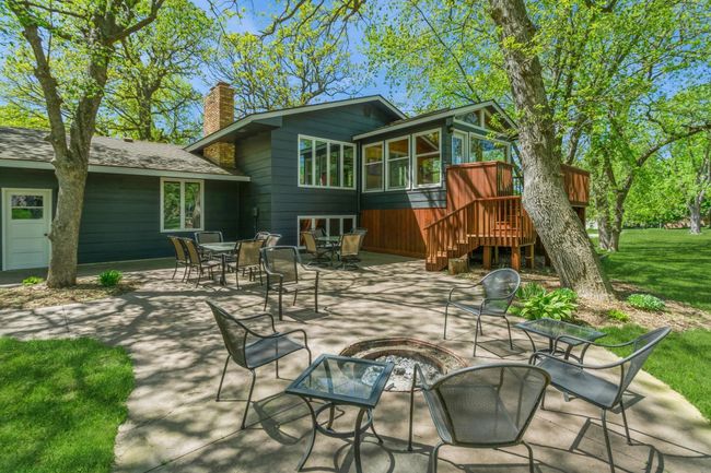 Endless possibilities with this beautiful stamped concrete patio! Enjoy time around your built in bonfire pit and still have tons of space for guest to gather for a picnic and to enjoy the shade. | Image 7