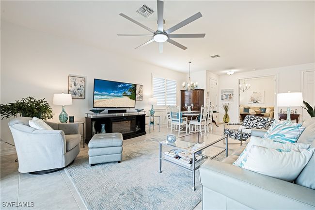 Living room with a chandelier, a ceiling fan, and light tile patterned flooring | Image 11