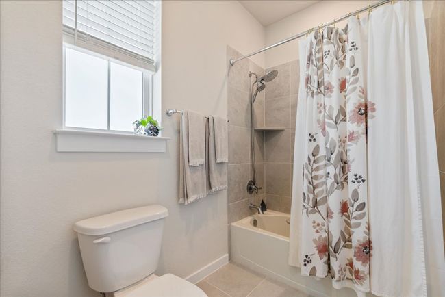 Full bathroom with tile patterned flooring, shower / tub combo, baseboards, and toilet | Image 32
