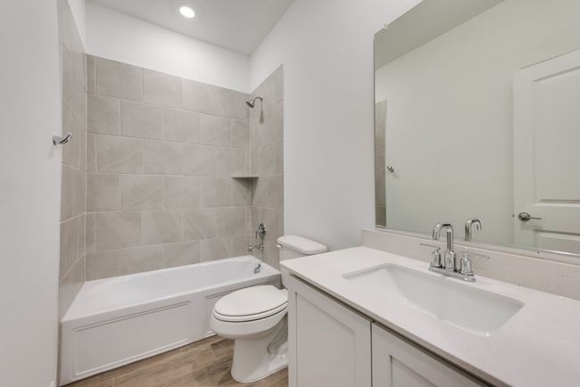 Bathroom featuring vanity, washtub / shower combination, wood finished floors, and recessed lighting | Image 9